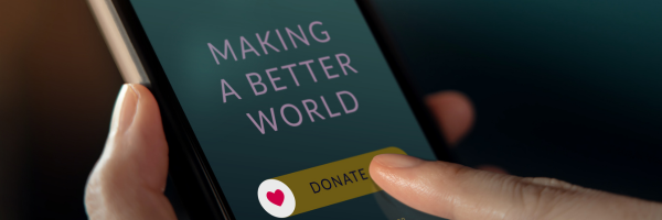 A hand is holding a phone with a Donate button highlighted on it.